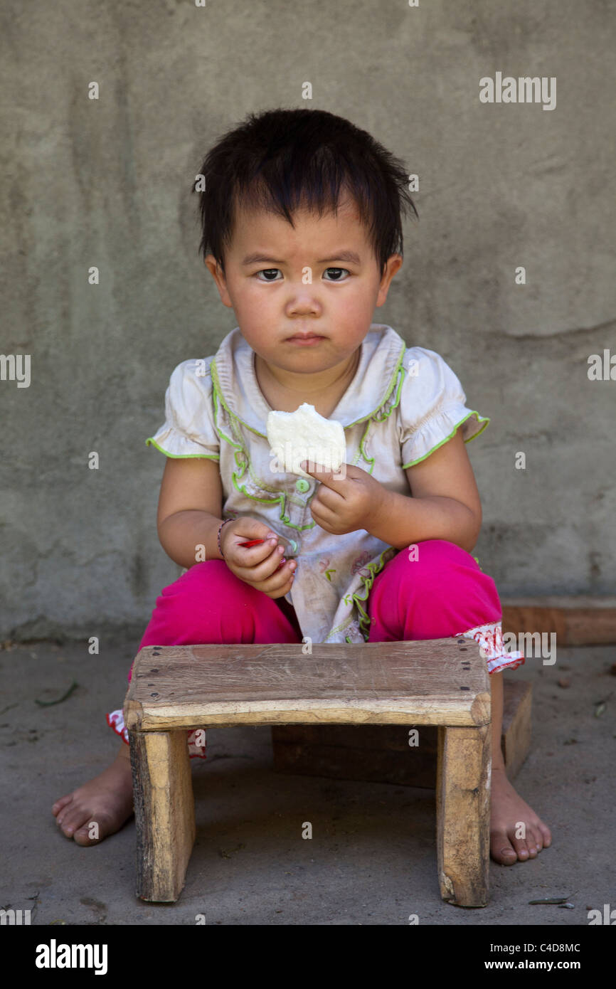 Vietnamesische Kind essen einen Garnelen-cracker Stockfoto