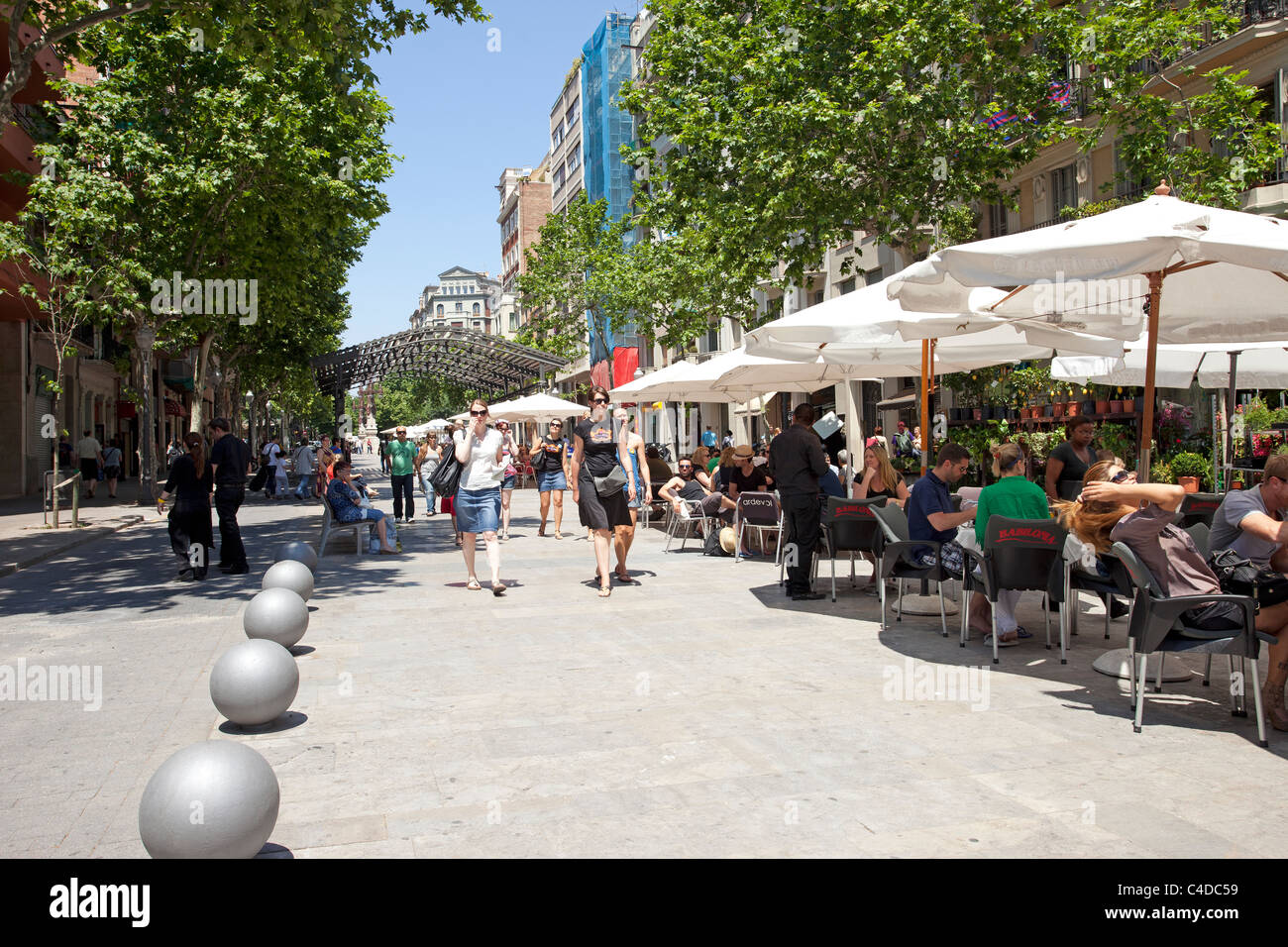 Ein Straßencafé in Barcelona, Spanien mit Kunden beim Mittagessen in der Sommersonne. Urbanen Kulisse mit hohen Gebäuden. Stockfoto