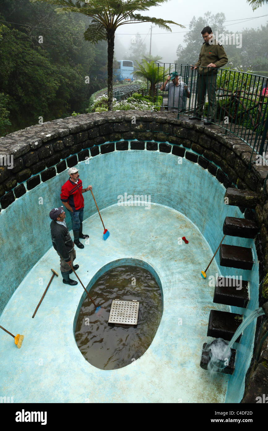 Forellen-Landarbeiter Reinigung einen Pool. Stockfoto