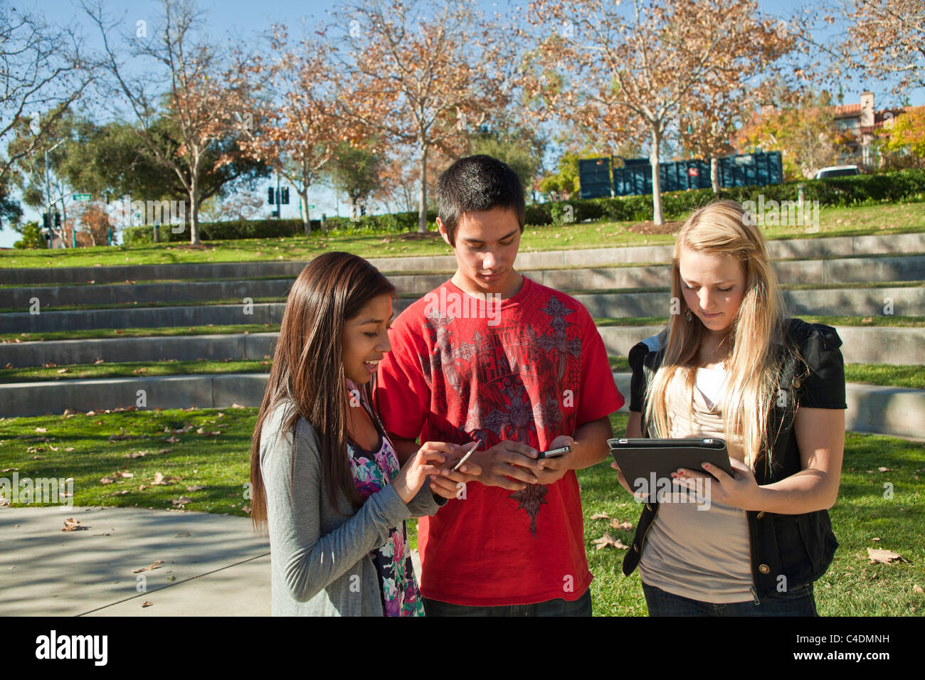 Multi ethnischen Rasse ethnisch Gruppe Teenager mit iPad iPhone mobile Telefon Blackfoot American Indian, Hispanic Jugendliche 14-17 Jahre alt alt alt Stockfoto