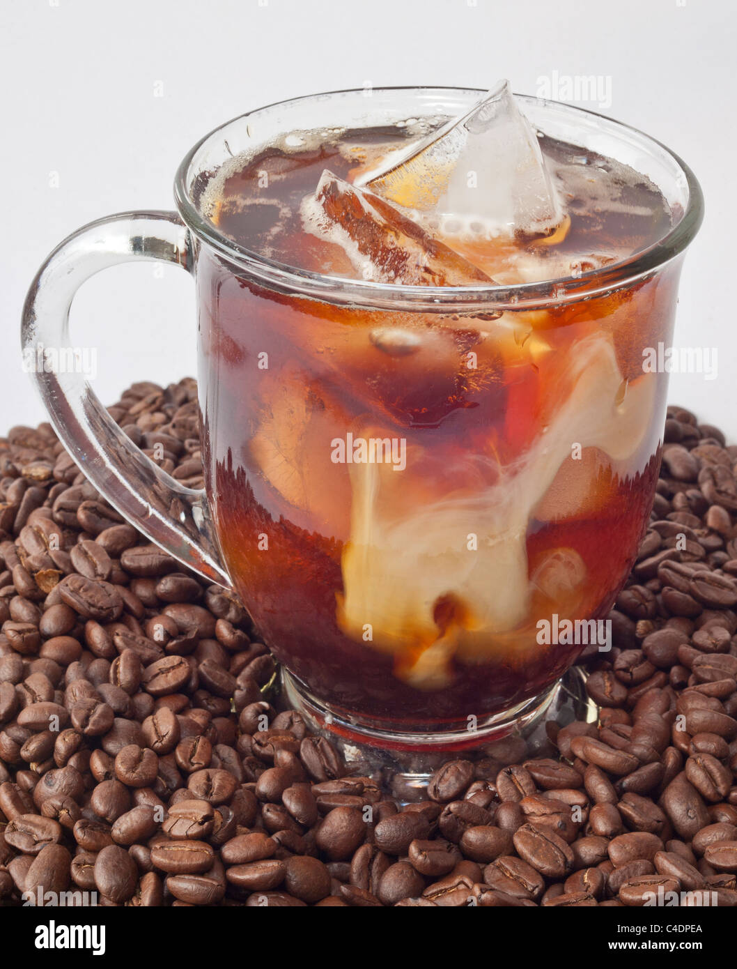 Tasse Eiskaffee auf einen Haufen von Bohnen Stockfoto