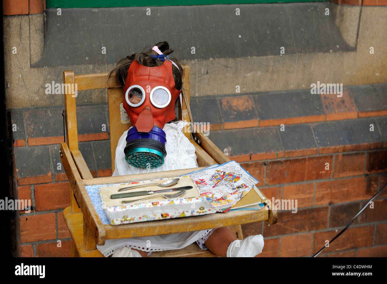 Krieg-Zeitanzeige Puppe mit einer Gasmaske sitzen in einem Baby Stuhl Loughborough England uk Stockfoto