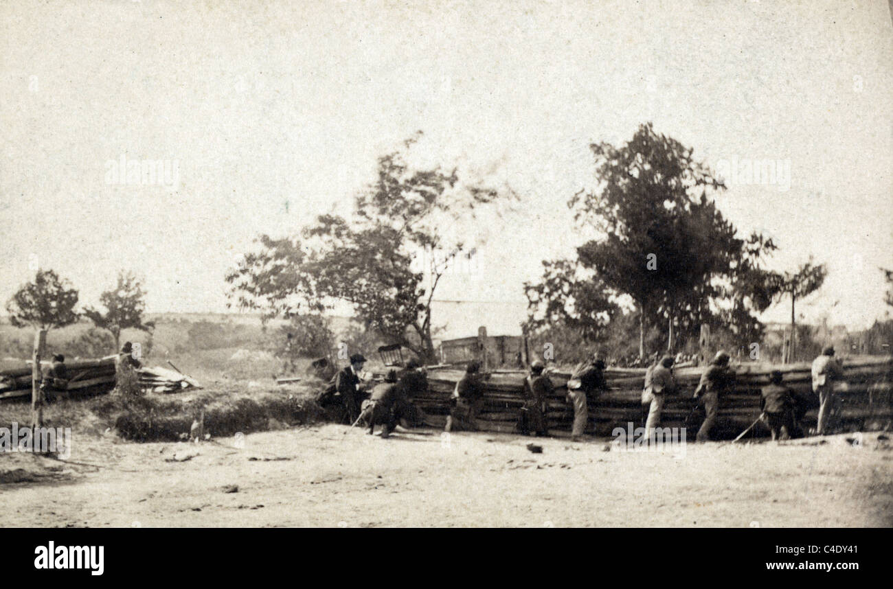 Bürgerkrieg-Soldaten im Einsatz mit Soldaten feuern Gewehre hinter Barriere. Stockfoto