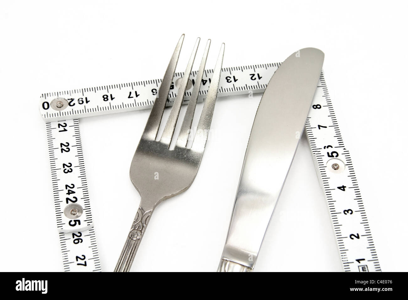 Faltbare Maßband und Gabel mit weißem Hintergrund, Konzept der Ernährung Stockfoto