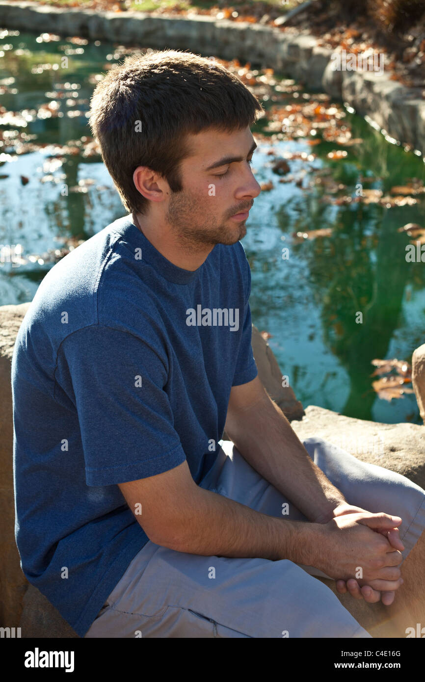 15-18 jährigen Mann jährigen Jungen Meditation, Gebet und nachdenklich allein im Park. Herr © Myrleen Pearson Stockfoto