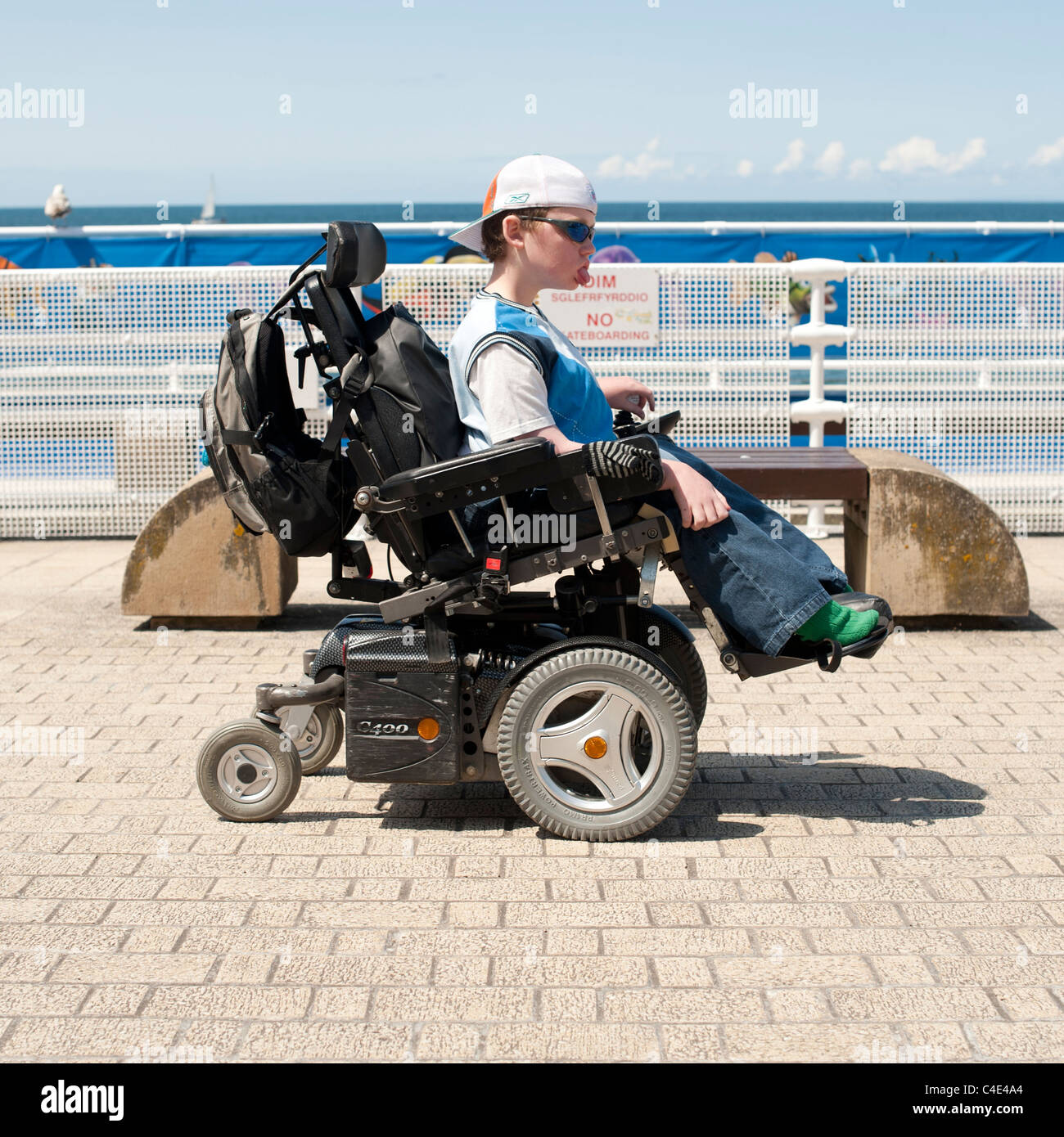 Ein junger behinderter Mann in einer Batterie angetrieben motorisierten Rollstuhl UK Stockfoto