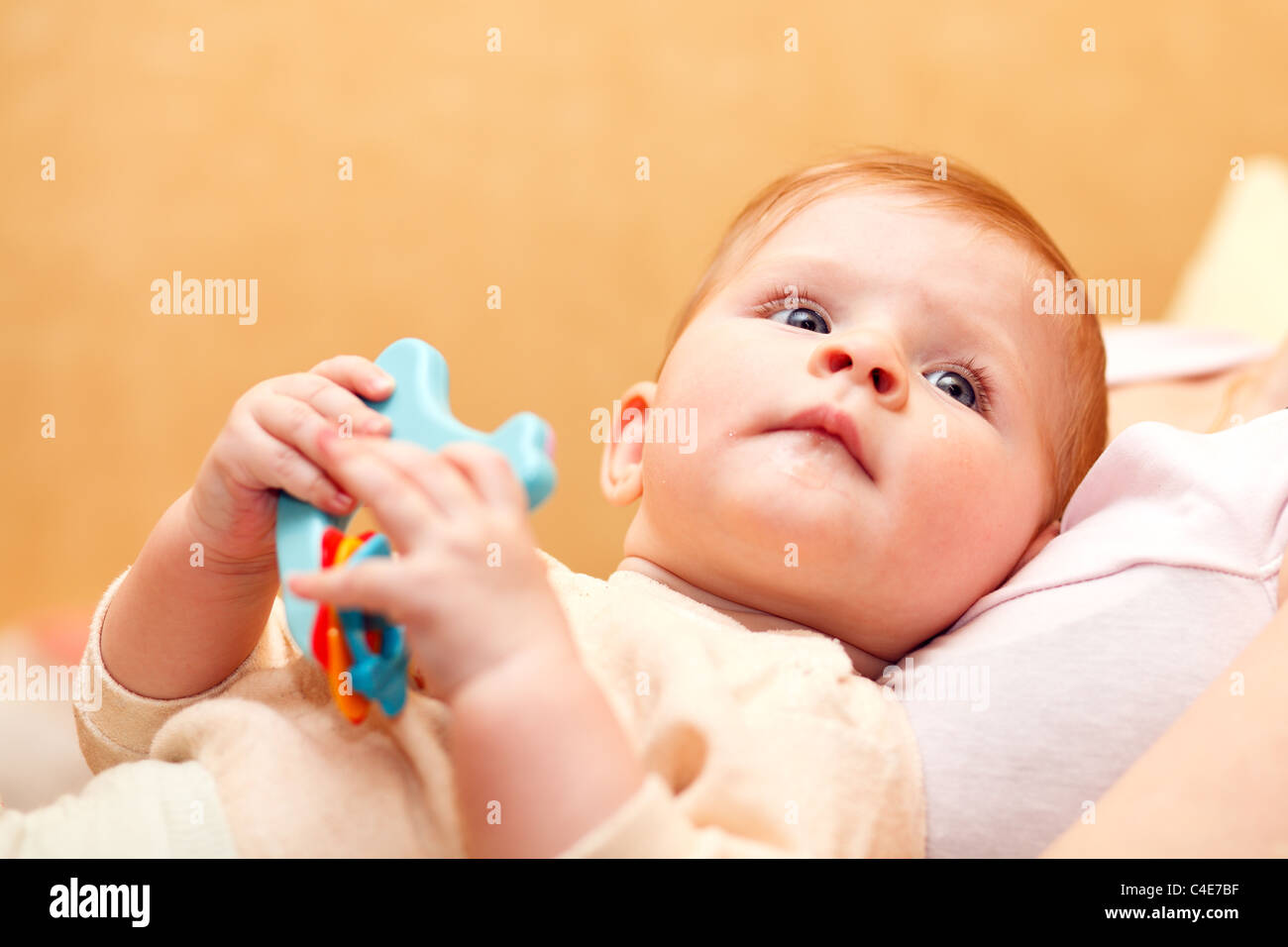 Baby mit Kunststoff-Spielzeug in der Hand. Stockfoto