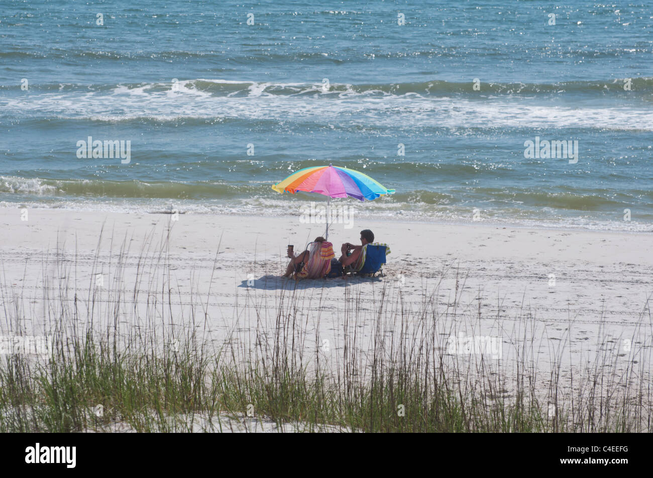 Golf-Strände Floridas Panhandle im St. Joseph Peninsula State Park. Paar erholsame unter einem Sonnenschirm an einem sonnigen Tag Stockfoto