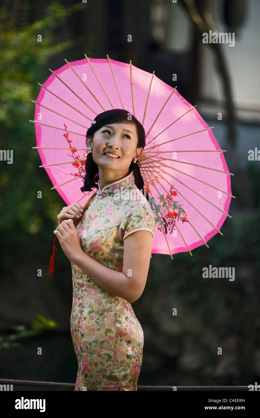 Frau in einem Qipao in dem Garten der Freude. Suzhou, China
