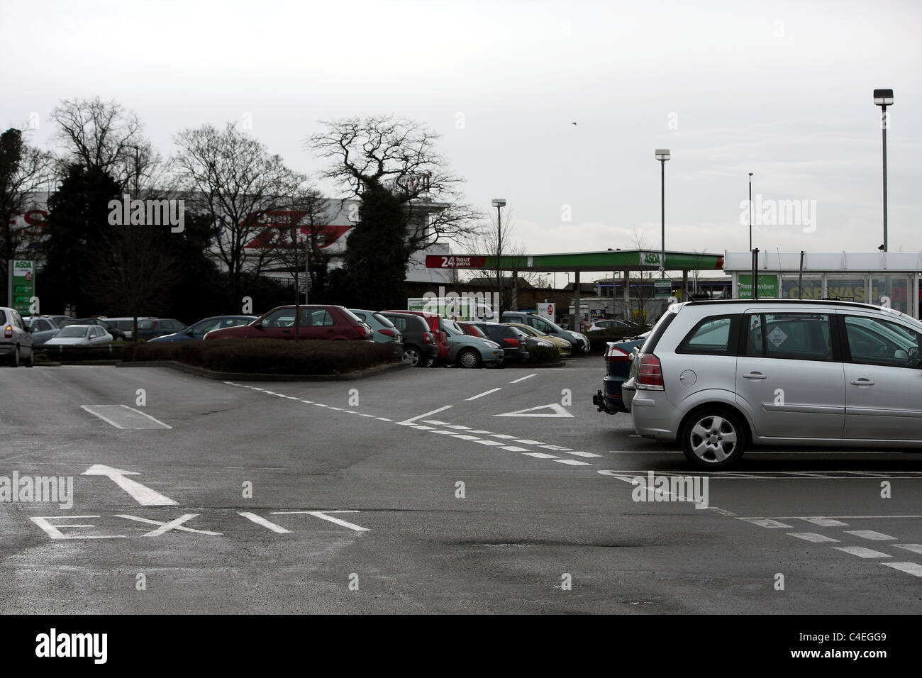 Der Pfeil zeigt den Weg aus einem Parkplatz in einem grauen tristen Wintertag und Notausgangsschild. Stockfoto