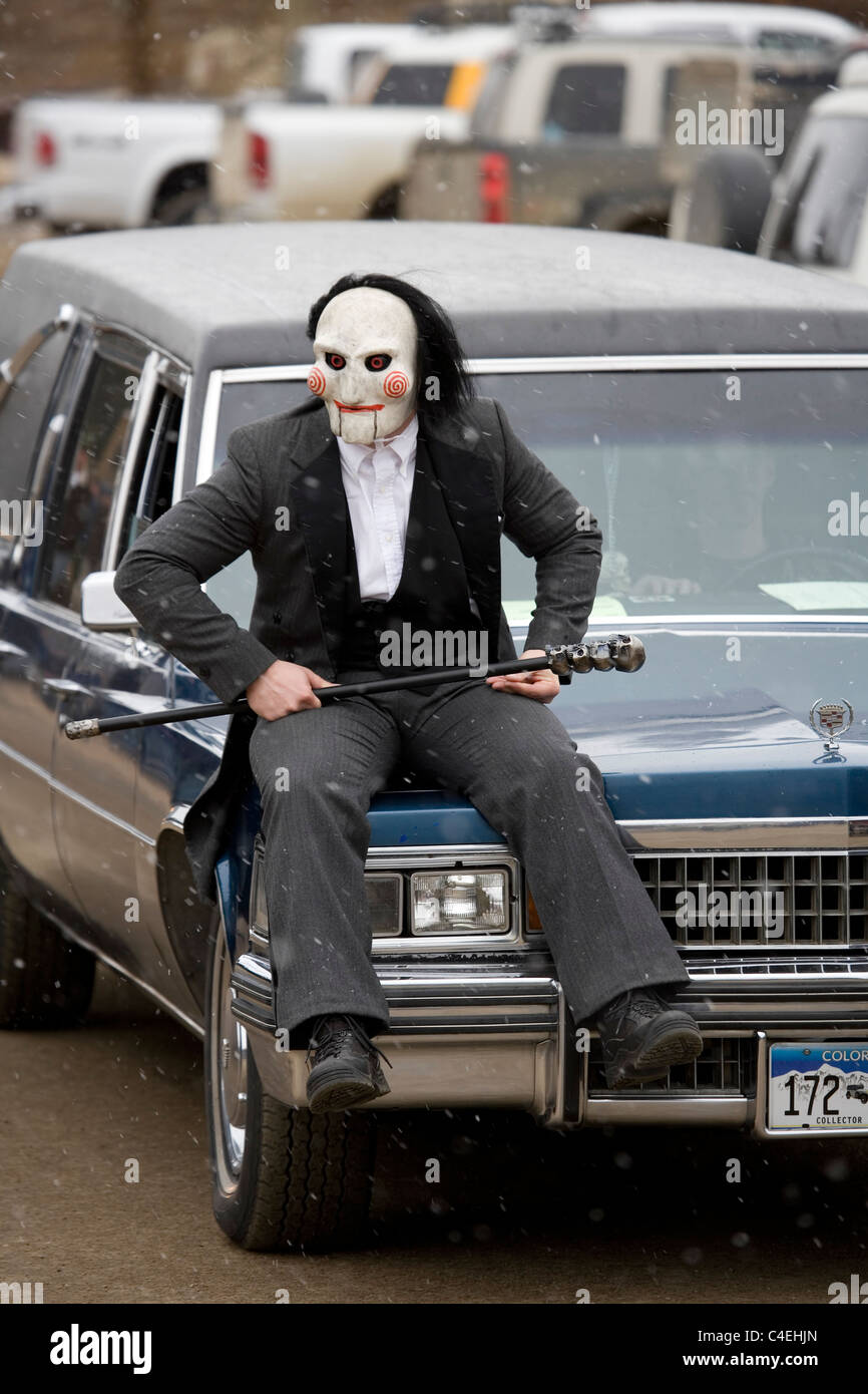 Eine Person in einem Ghul Kostüm gekleidet reitet auf der Motorhaube ein Leichenwagen während einer Parade auf dem eingefroren Dead Guy Festival Stockfoto