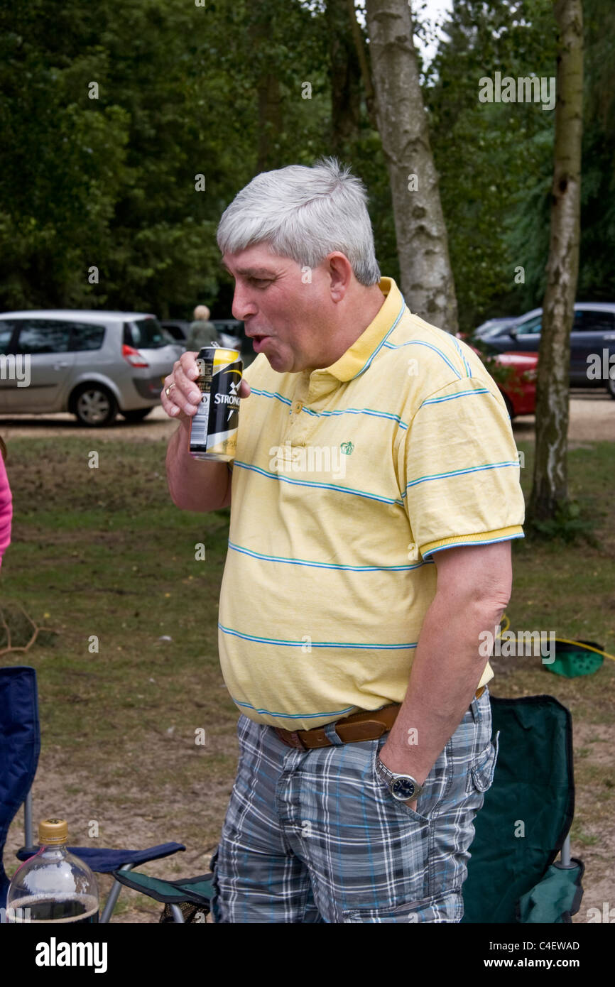 Reifer Mann trinken Apfelwein aus der Dose bei einem Picknick Stockfoto