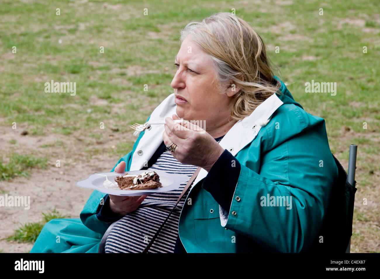 Frau, essen Schokolade Kuchen bei einem Picknick Stockfoto