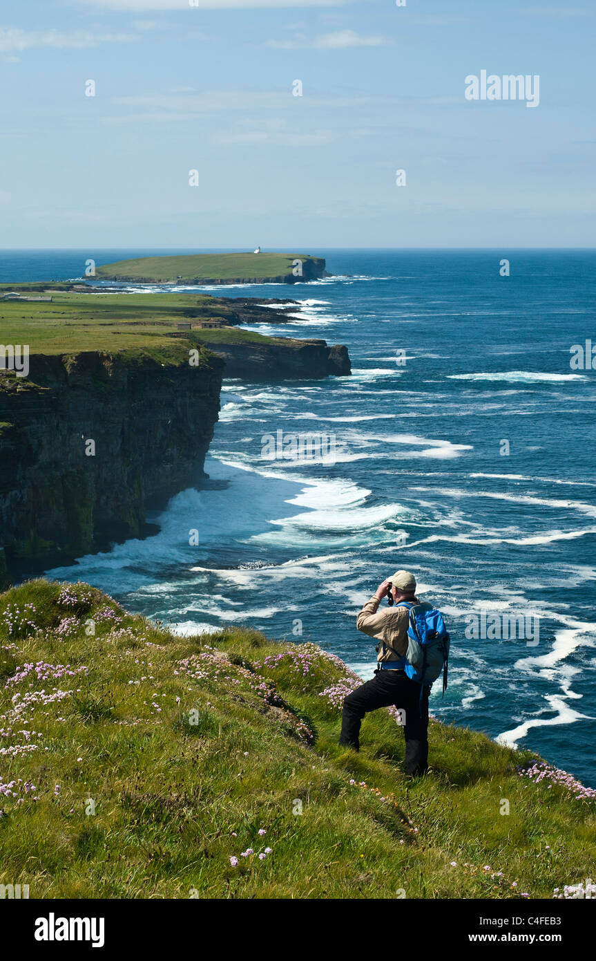 dh Scottish Seacliffs UK BIRSAY ORKNEY Vogelbeobachter mit Fernglas beobachten Vogelbeobachter Klippe Meer Mann Beobachter Ansichten schottland Küste Stockfoto