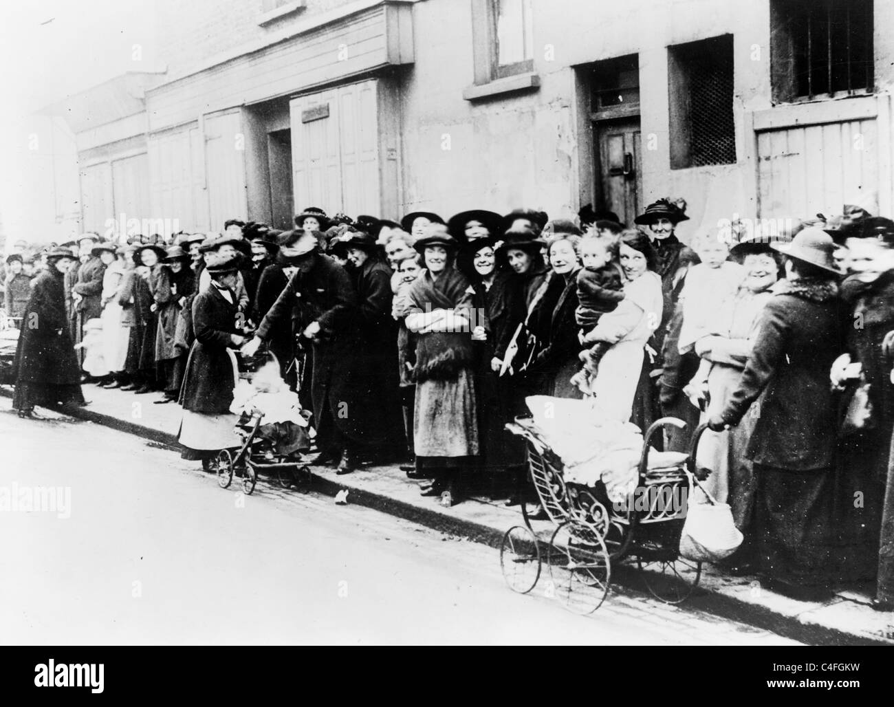 Frauen und Kinder warten in eine Brotlinie in Kriegszeiten England. Stockfoto