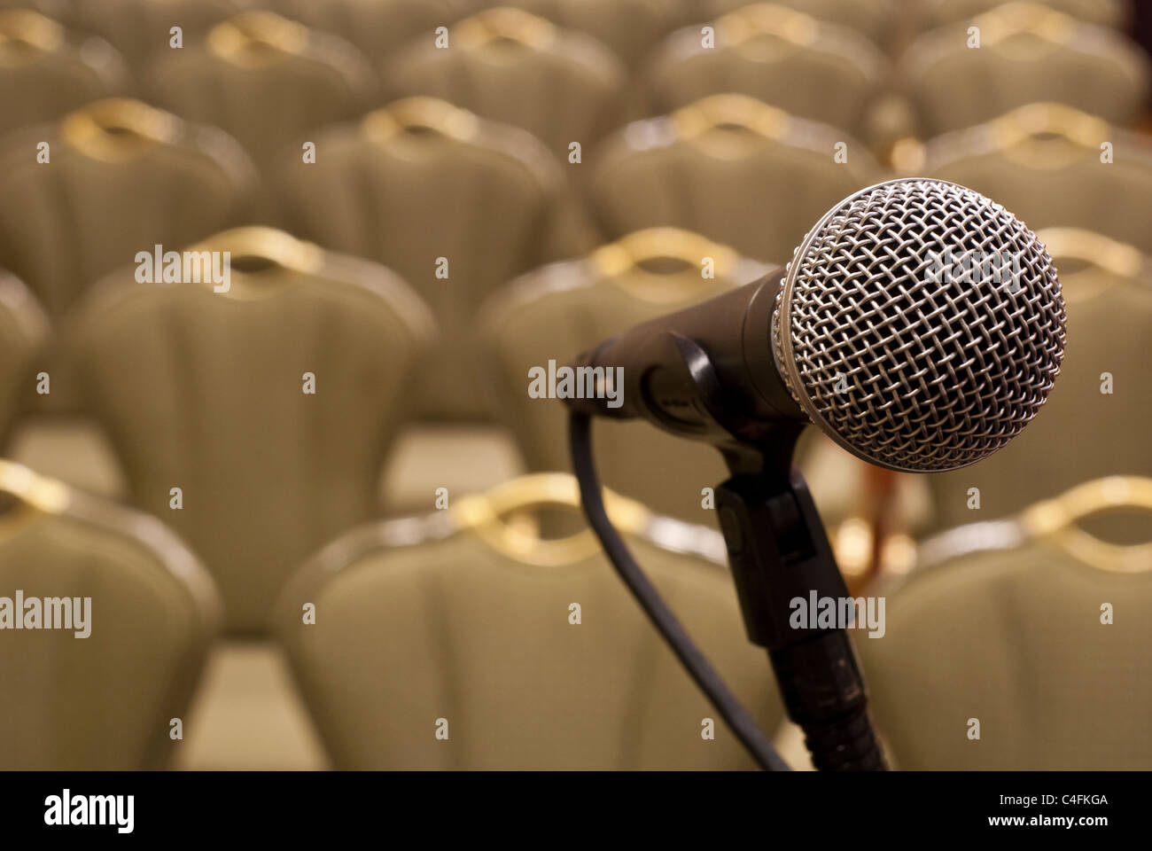Mikrofon vor mehreren leeren Stuhlreihen mit geringen Schärfentiefe Stockfoto