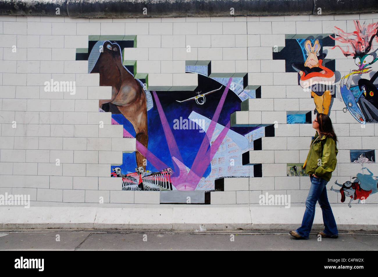 Ein Mädchen geht Vergangenheit malte das Album-Cover von Pink Floyd The Wall auf der Berliner Mauer an der East Side Gallery Stockfoto