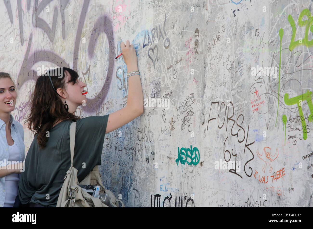 Ein Mädchen schreiben an der Berliner Mauer Stockfoto