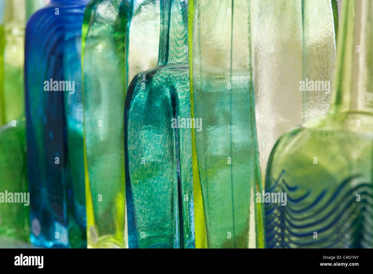 Nahaufnahme von mundgeblasenes Farbglas Flaschen hintereinander Stockfoto
