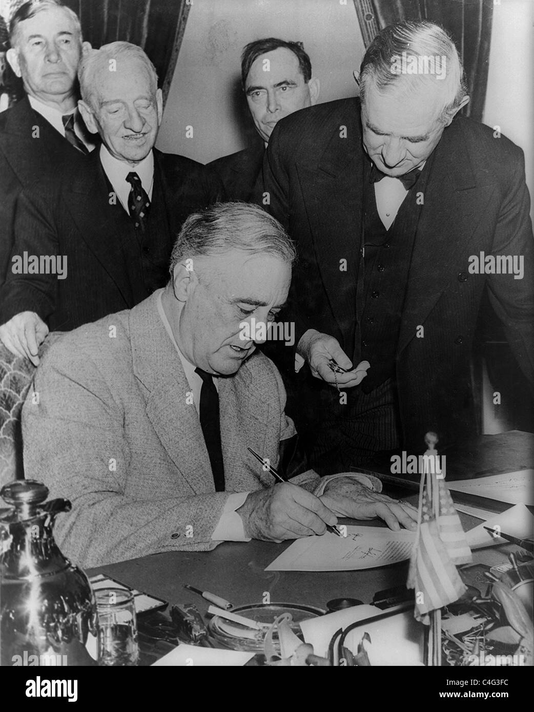 Präsident Franklin D. Roosevelt, sitzen am Schreibtisch, mit vier Männern hinter ihm steht. Dezember 1941. Stockfoto