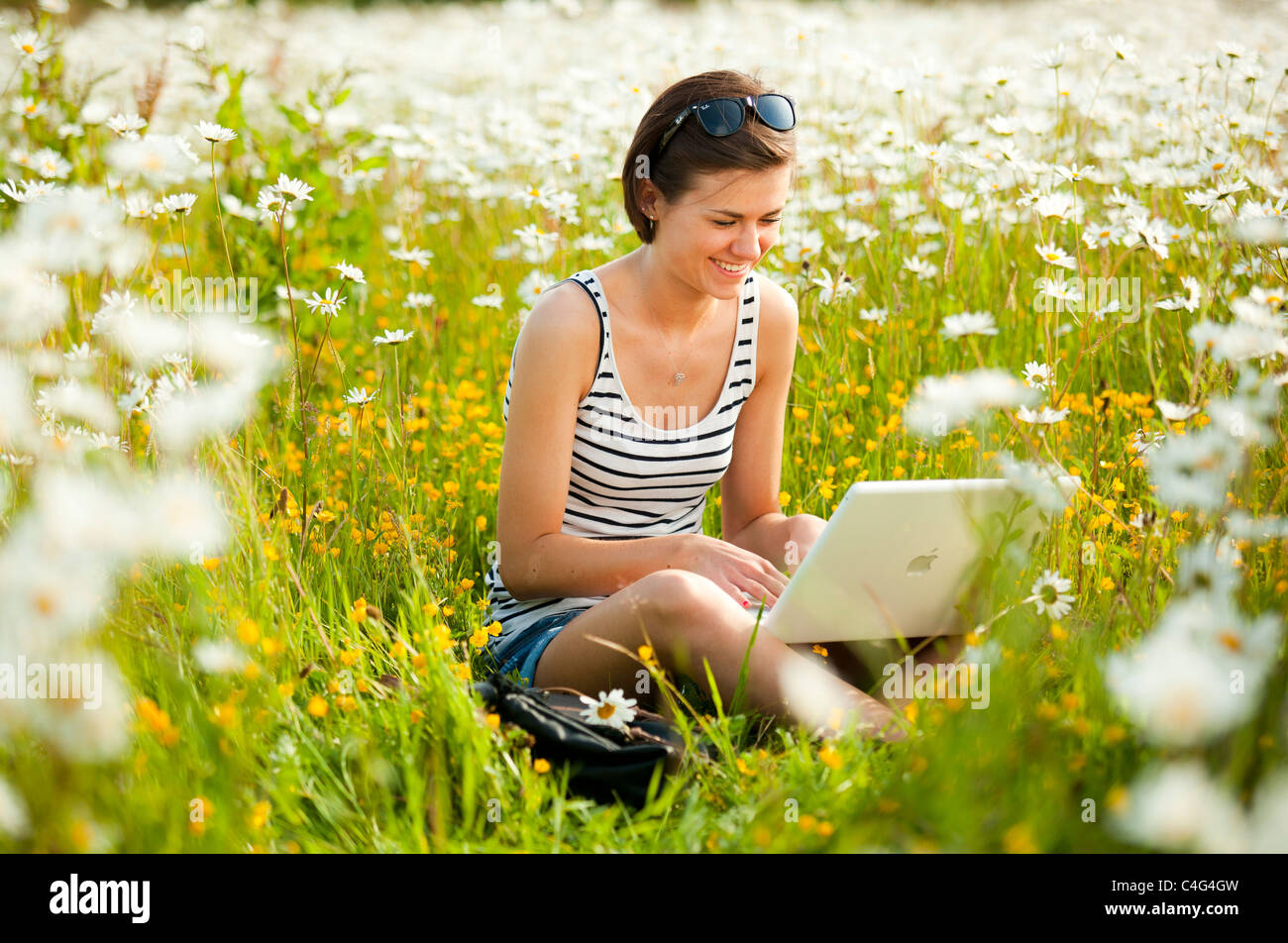 Mädchen arbeiten im Freien mit laptop Stockfoto