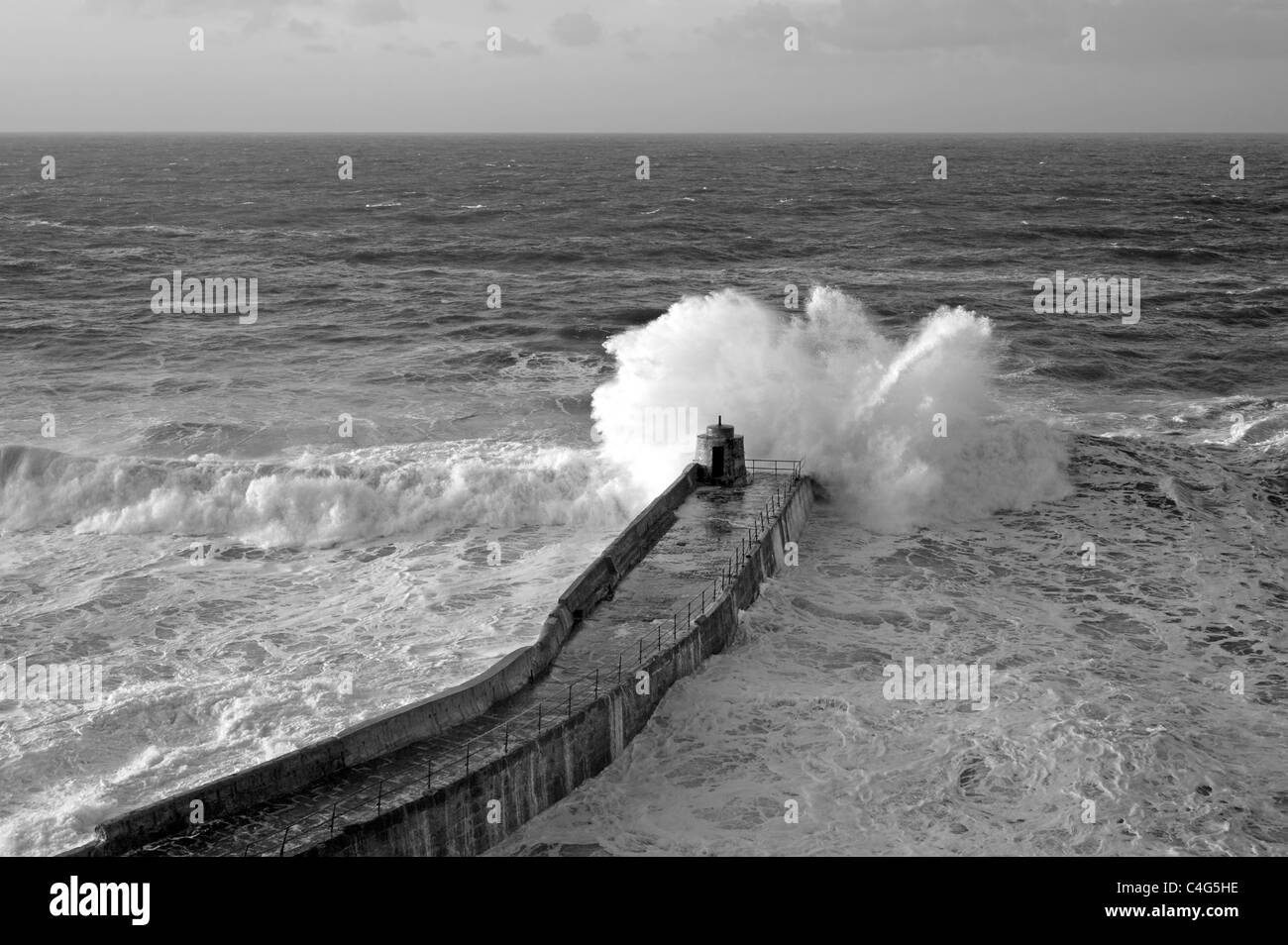 Eine große atlantische Welle bricht am Pier Portreath, Cornwall UK. Stockfoto