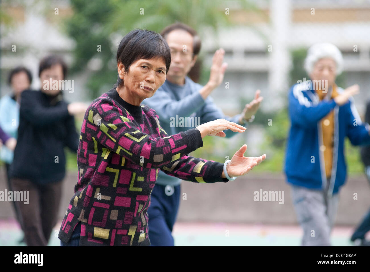 Eine ältere chinesische Dame während eines frühen Morgens Tai Chi Sitzung in Mongkok auf der Halbinsel Kowloon, Hong Kong Stockfoto