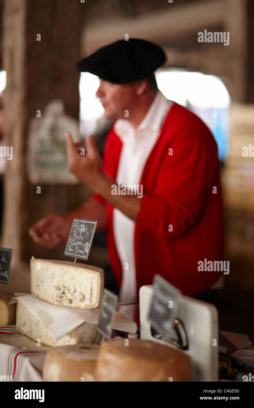 ein Mann verkauft Käse auf dem Markt in Revel, Languedoc, Midi-Pyrenäen, Frankreich Stockfoto