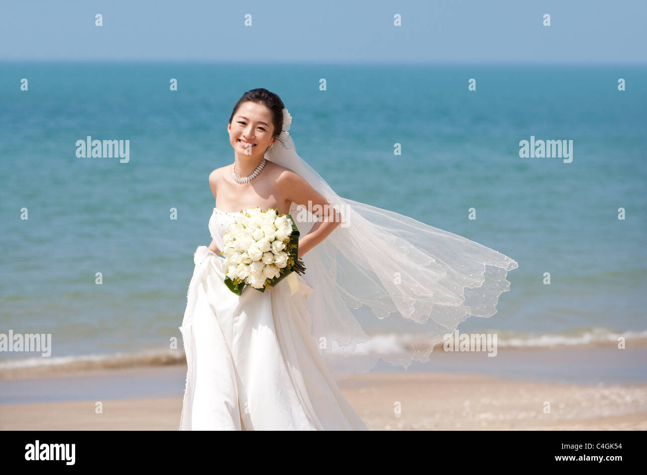 Glückliche Braut laufen am Strand Stockfoto