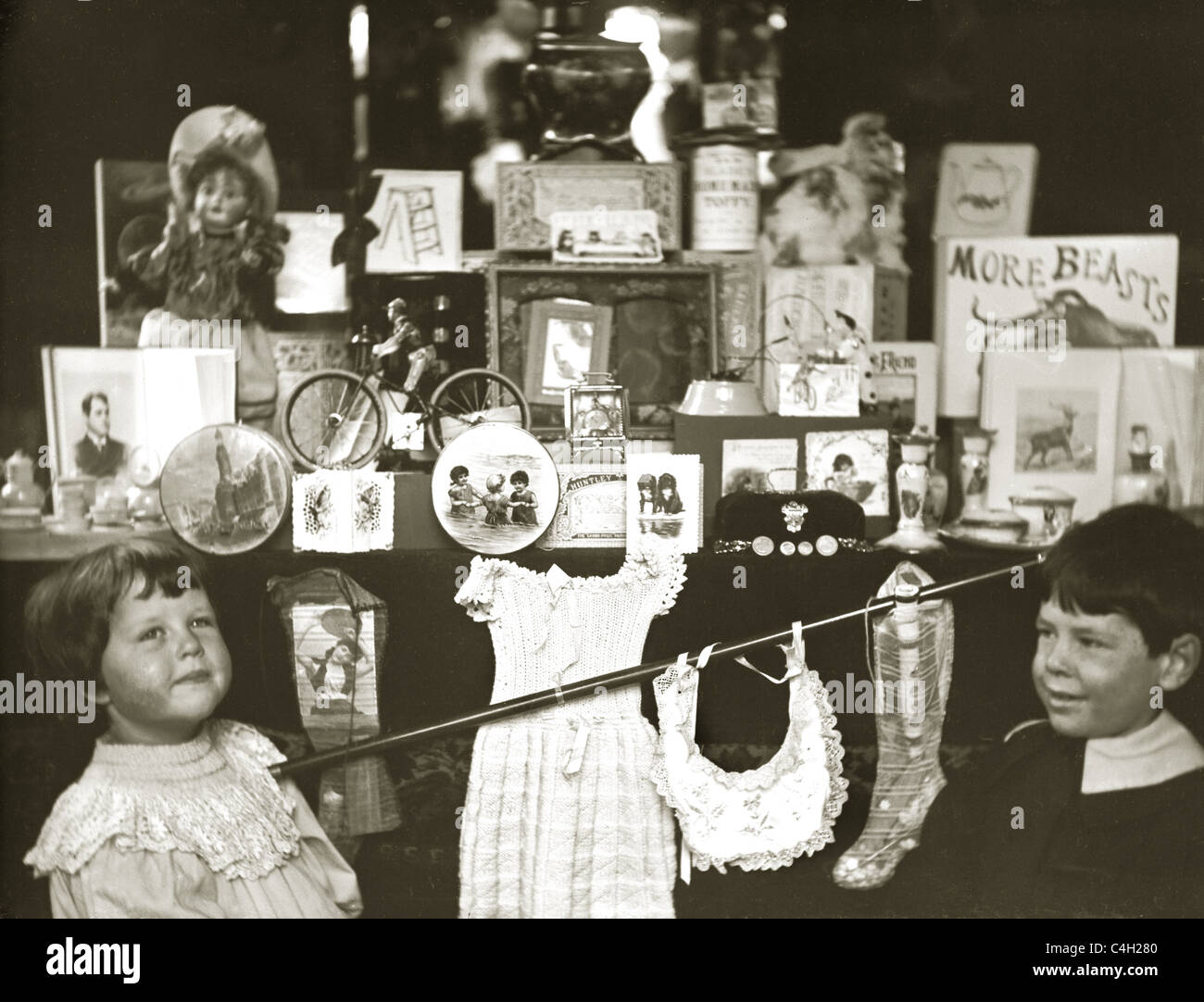 Originalfoto von edwardianischen oder viktorianischen Kindern, die durch das Schaufenster/die Ladenfront eines Spielwarenladens im Retro-Stil aus den 1890 Jahren 1890 schauten. Stockfoto
