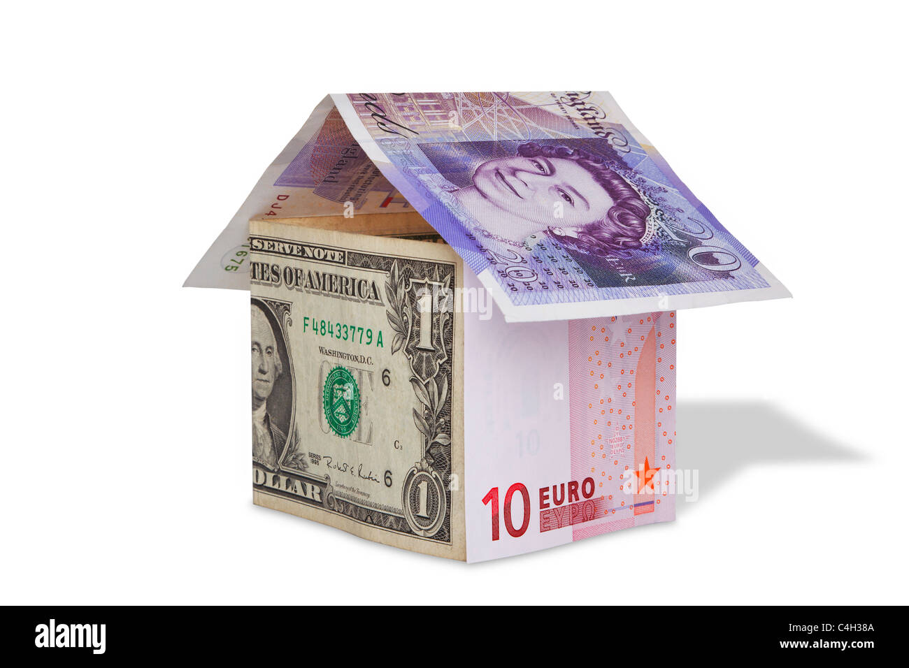 Foto von einem Haus aus britische Pfund, US Dollar und Euro-Banknoten, isoliert auf weiss mit Beschneidungspfad. Stockfoto