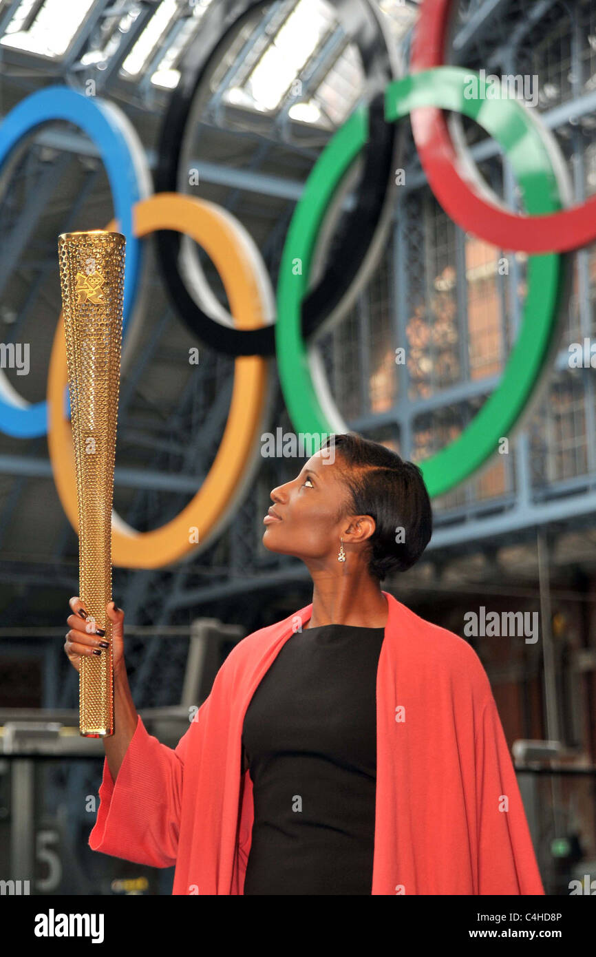 Denise Lewis schaut an der Fackel, da er es unter den Olympischen Ringen hält. 2012 Olympische Fackel London Stockfoto