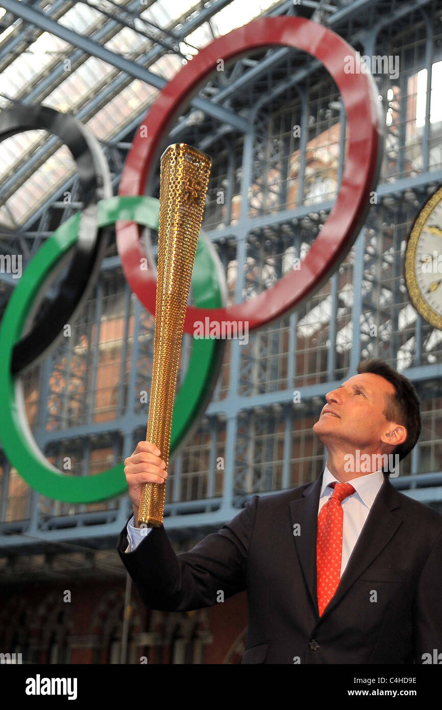 Sebastian Coe (Vorsitzender des LOCOG) schaut an der Fackel, da er es unter den Olympischen Ringen hält. 2012 Olympische Fackel London Stockfoto