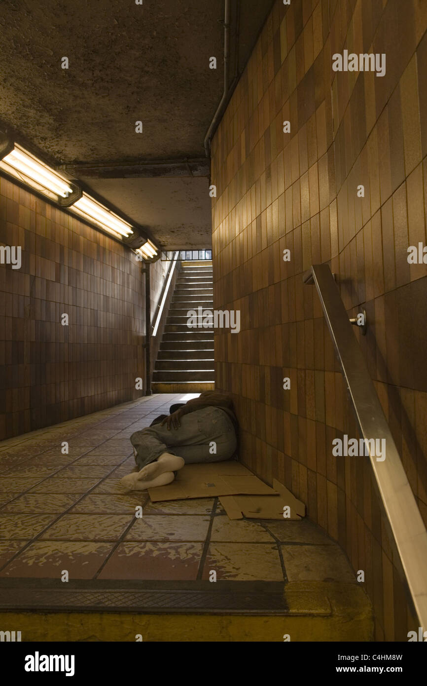 Obdachloser schlafen in u-Bahn Eingang/Ausgang, Rockefeller Center, New York City. Stockfoto