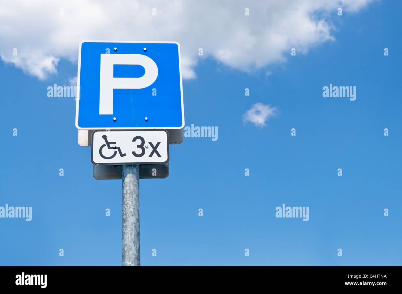 Behindertenparkplatz Zeichen und blauer Himmel mit Wolken Stockfoto
