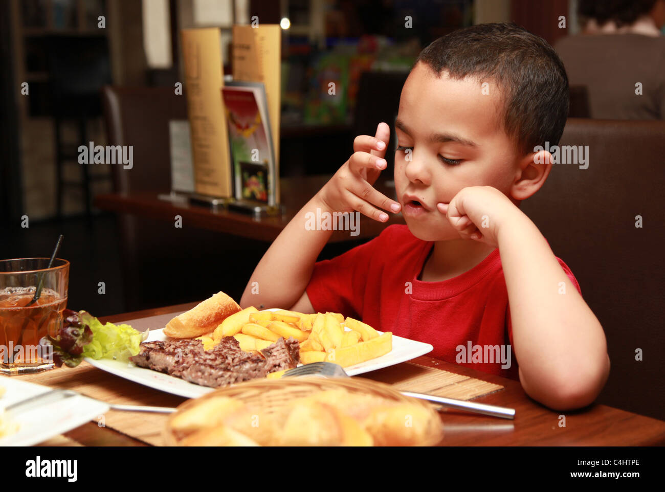 4 Jahre alter Junge in einem Restaurant nicht seine Mahlzeit Stockfoto
