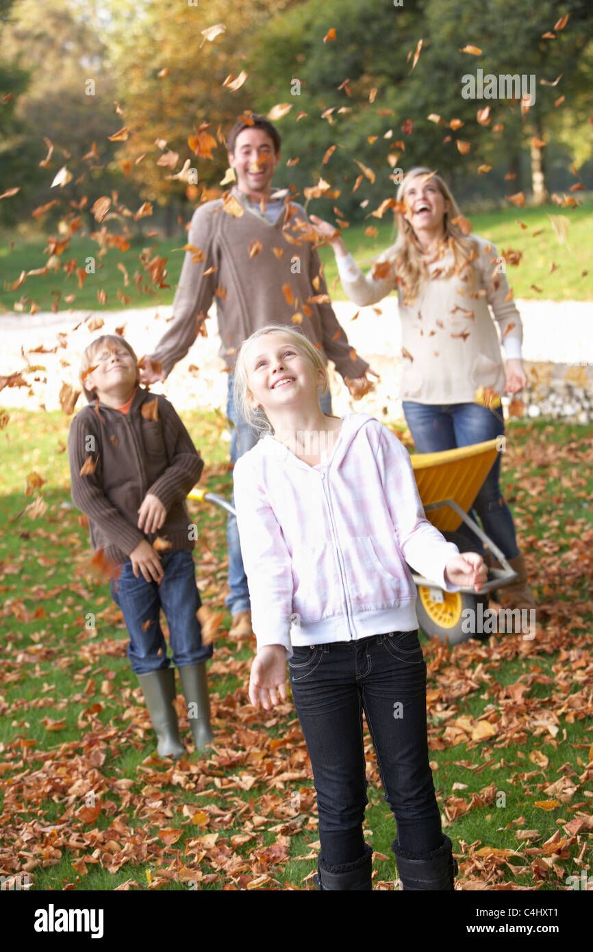 Familie Herbst wirft Blätter in der Luft im Garten Stockfoto