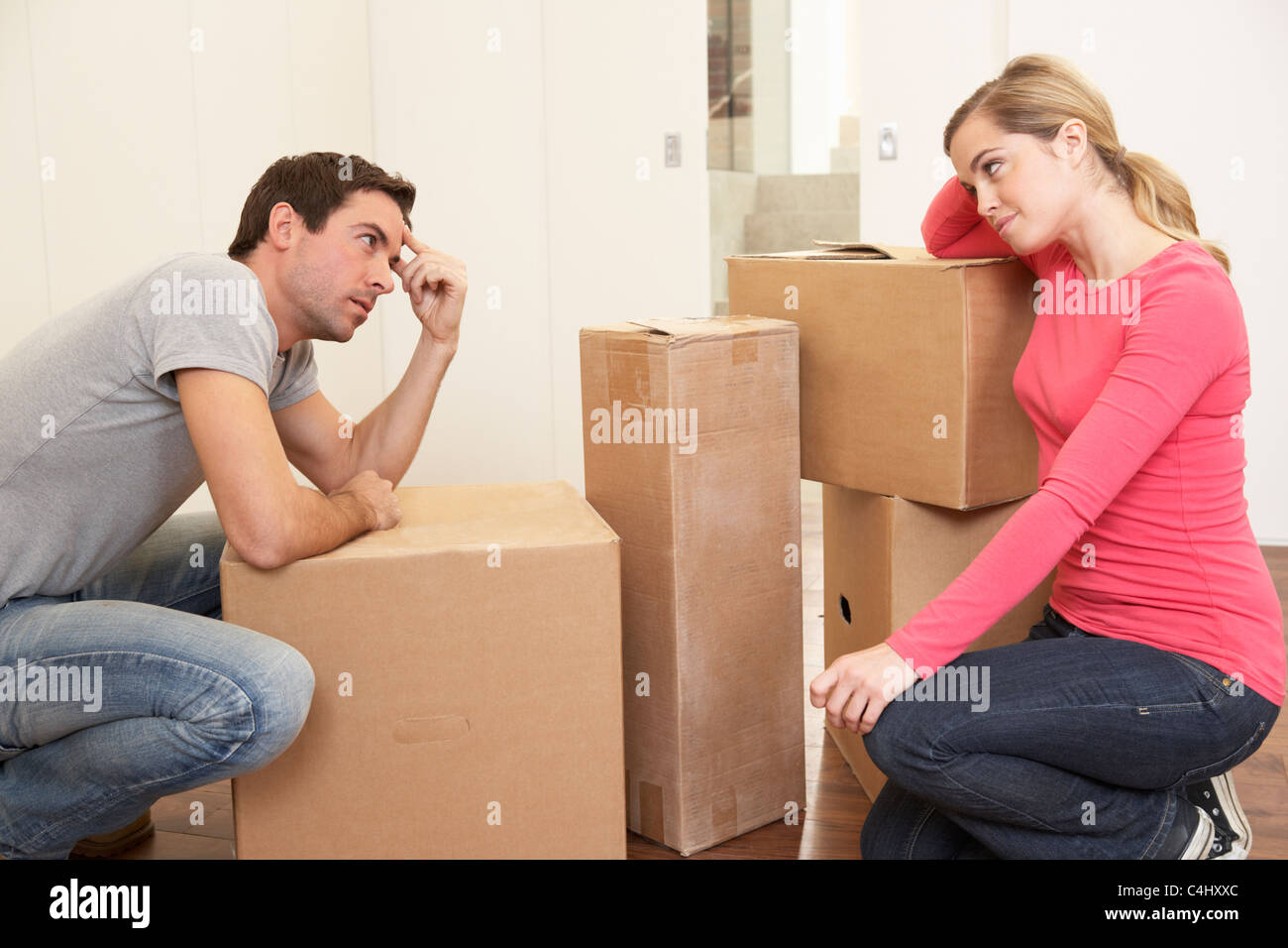 Junges Paar suchen verärgert unter Boxen Stockfoto