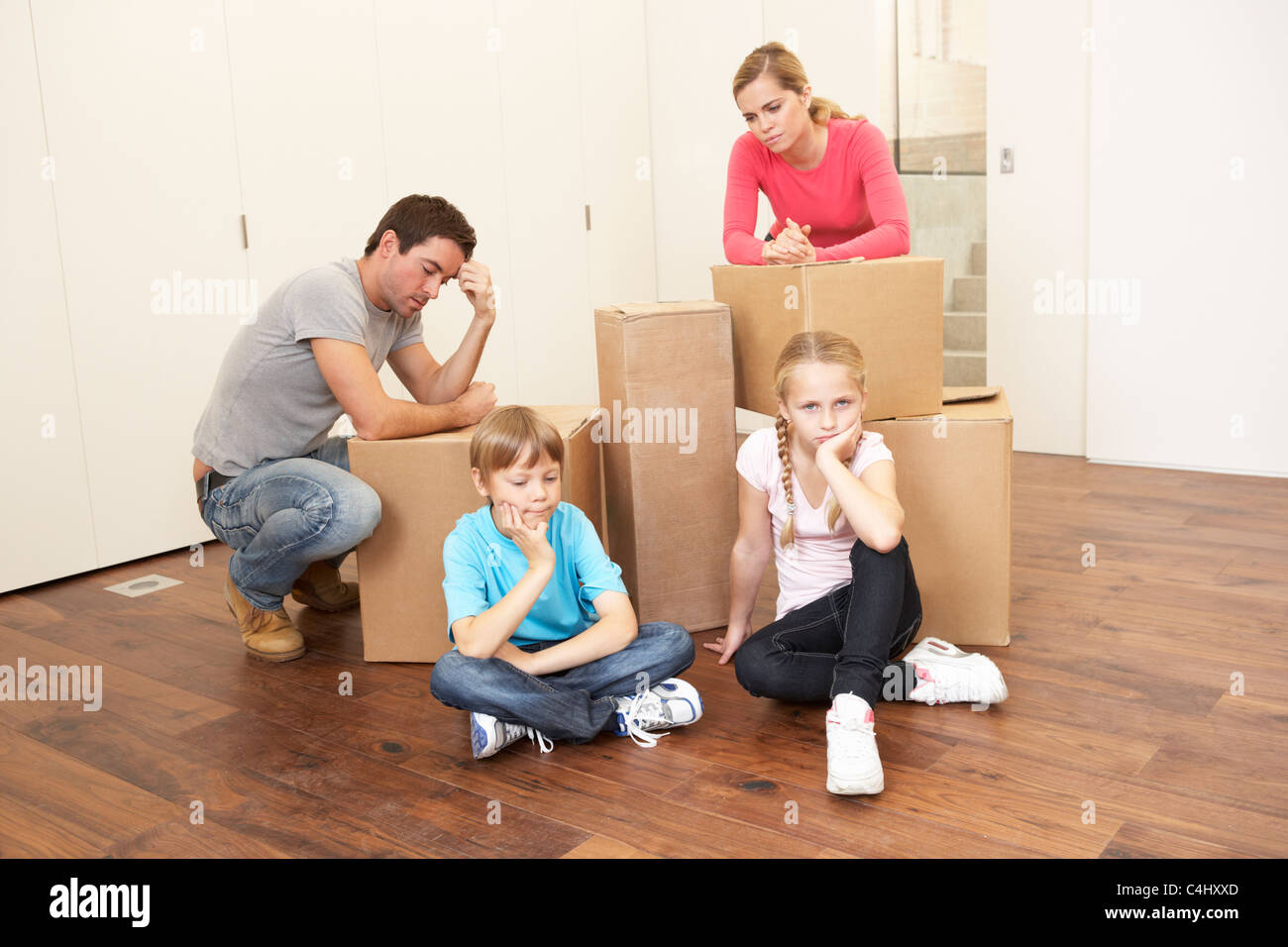 Junge Familie sucht aufgeregt unter Boxen Stockfoto