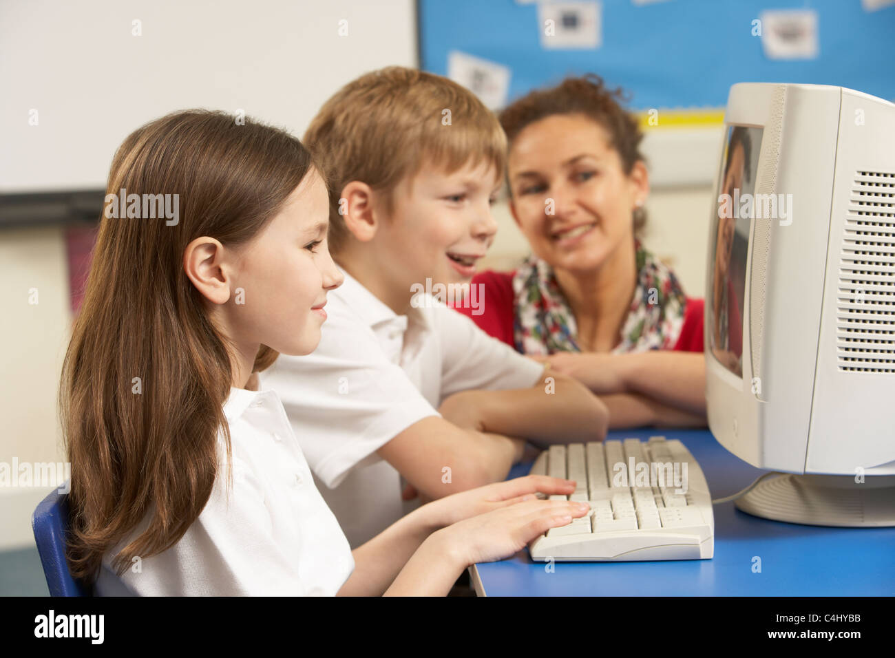 Schülerinnen und Schüler In der IT-Klasse verwenden Computer mit Lehrer Stockfoto