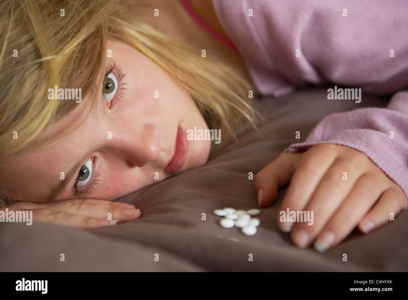 Depressive Teenager-Mädchen sitzen im Schlafzimmer mit Pillen Stockfoto