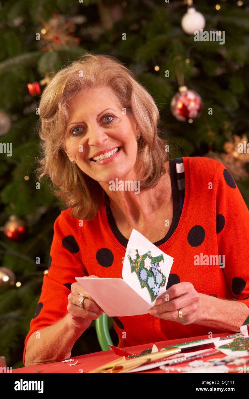 Ältere Frau, die Weihnachtskarten zu Hause machen Stockfoto