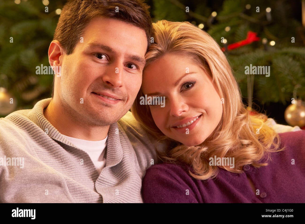 Paar vor Weihnachtsbaum entspannen Stockfoto