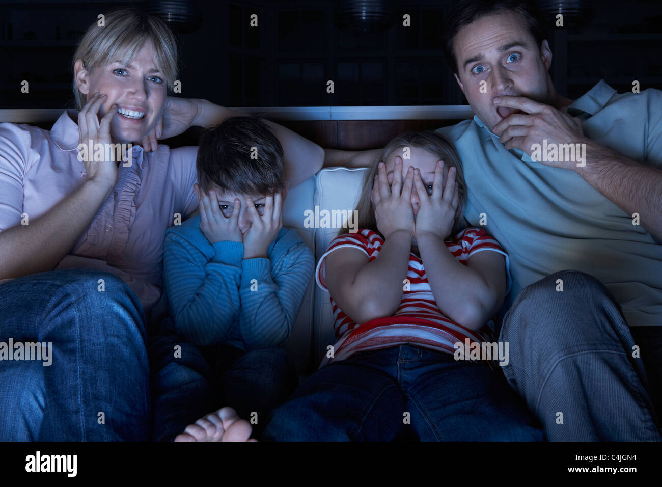 Familie vor dem beängstigend Programm im Fernsehen Zusammensitzen auf Sofa Stockfoto
