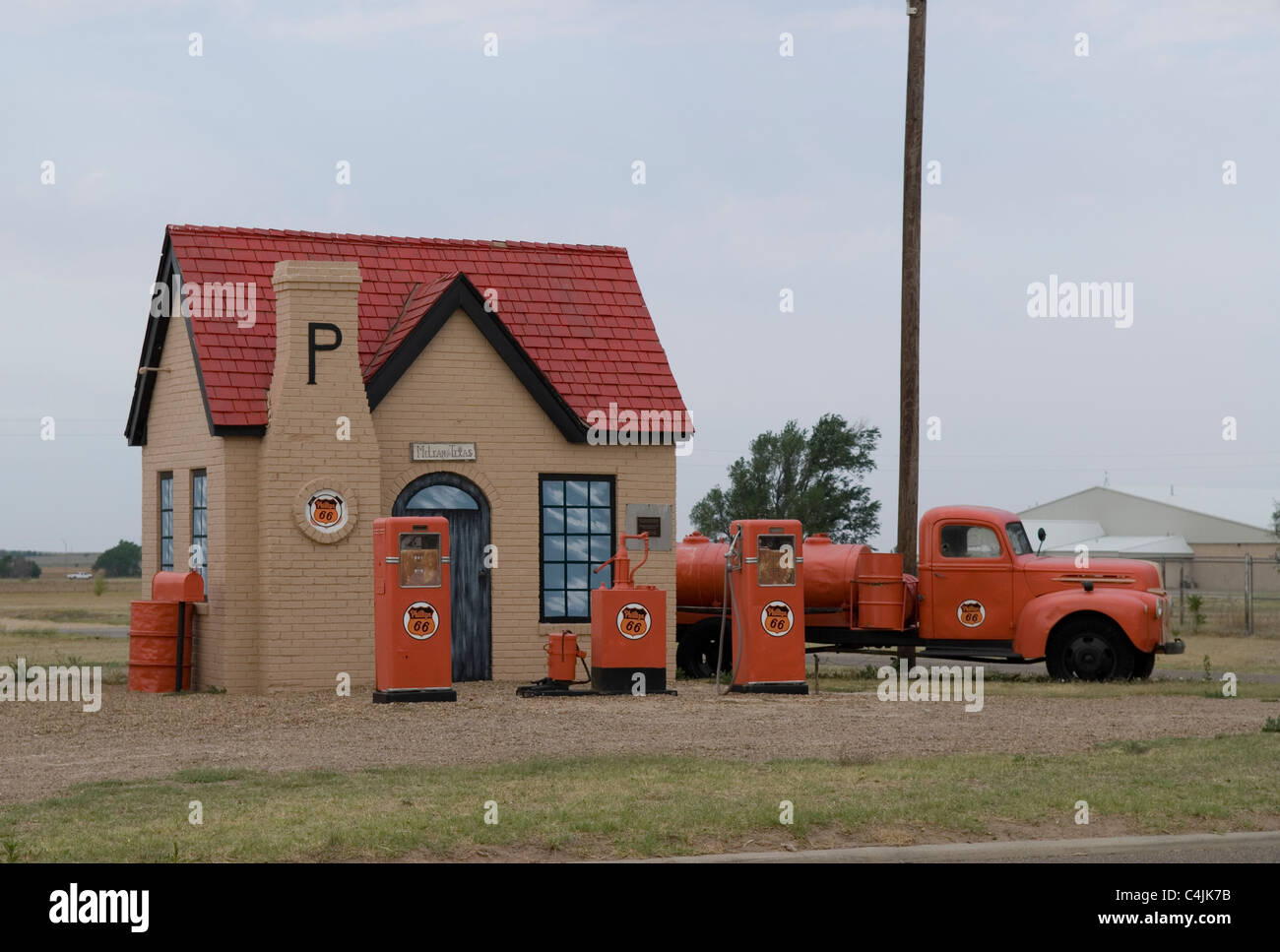 Außenansicht der historischen Phillips 66 Tankstelle mit orangefarbenen Gaspumpen und orangefarbenen Oldtimer-Lkw in McLean, Texas, USA, 1977 geschlossen. Stockfoto