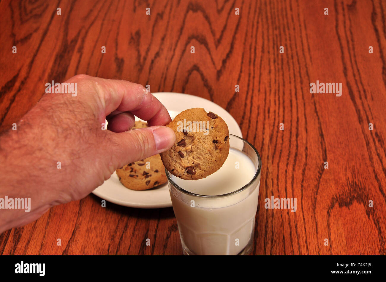 Ein Kampf, einen Cookie in einem kühlen Glas Milch dunk Stockfoto