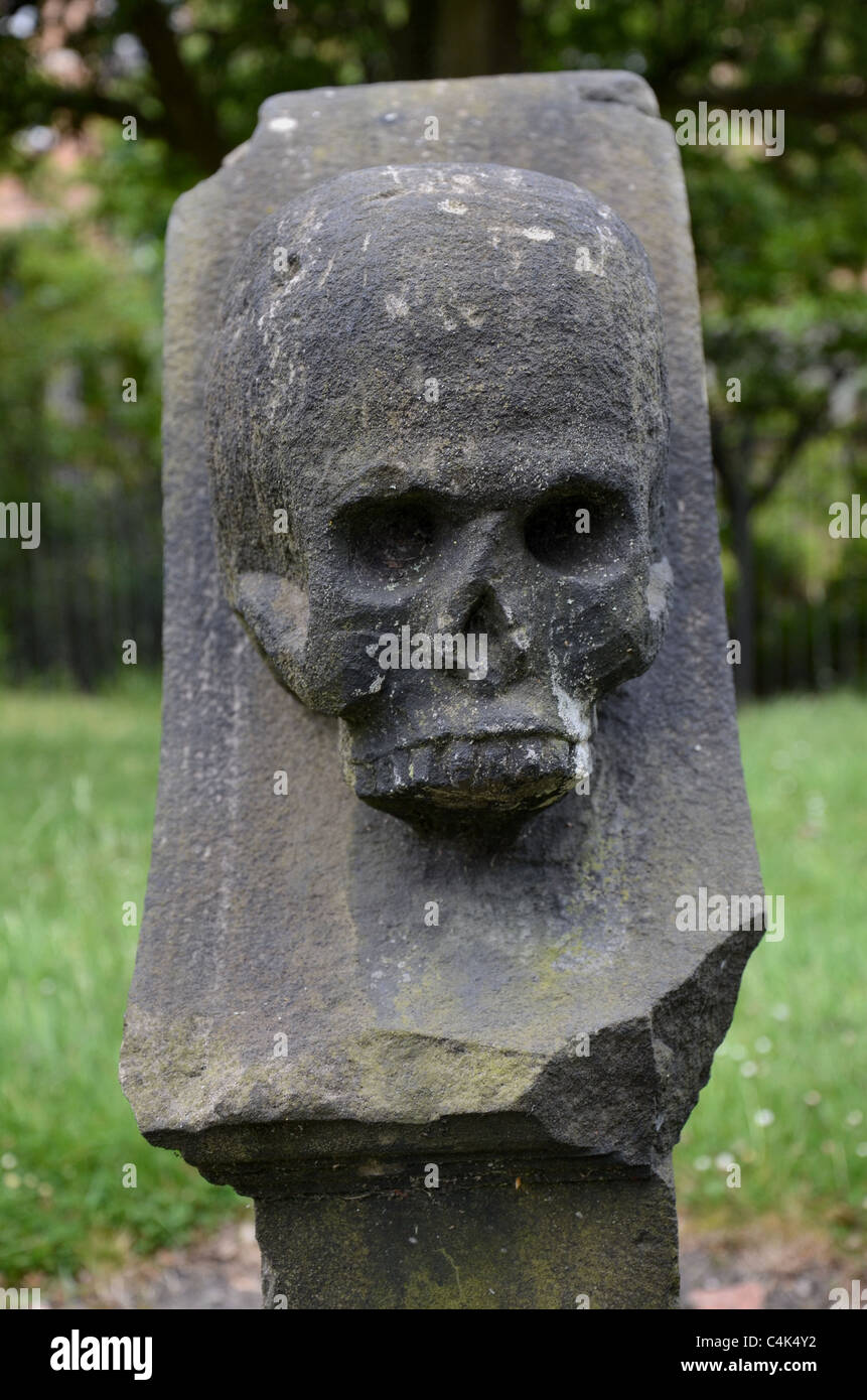 Ein Totenkopf auf der Seite einen Grabstein in North Leith Burial Ground, Edinburgh, Schottland. Stockfoto