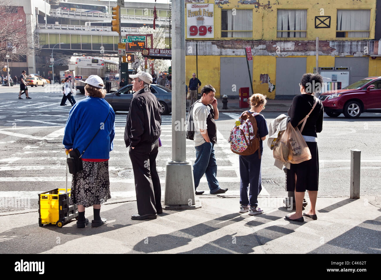 people waiting to cross street on spring day at corner of 42nd street & 9th Avenue New York City Stockfoto
