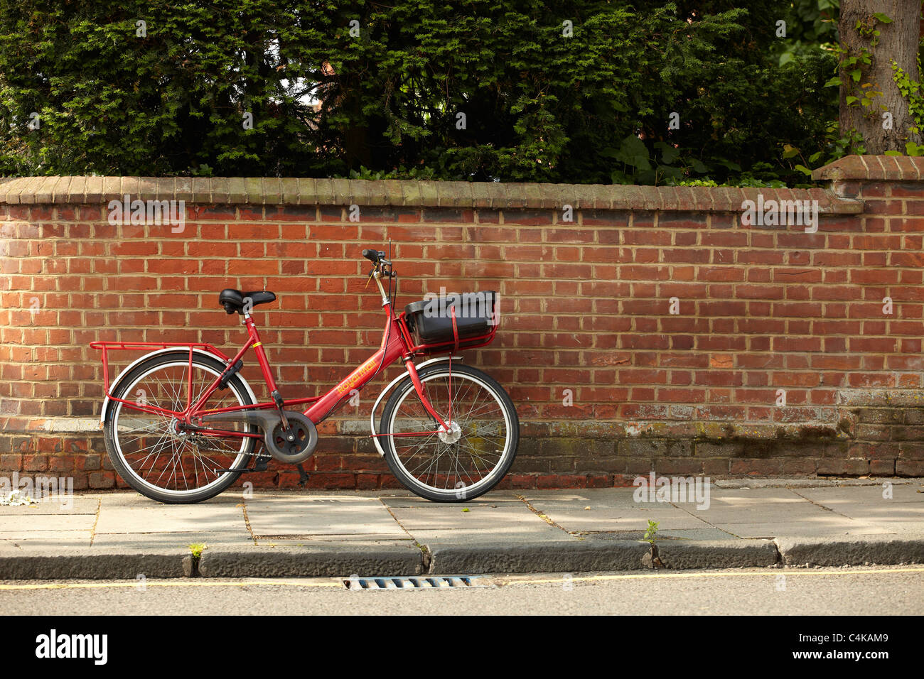 Ein Royal Mail-Fahrrad gegen eine Mauer gelehnt Stockfoto