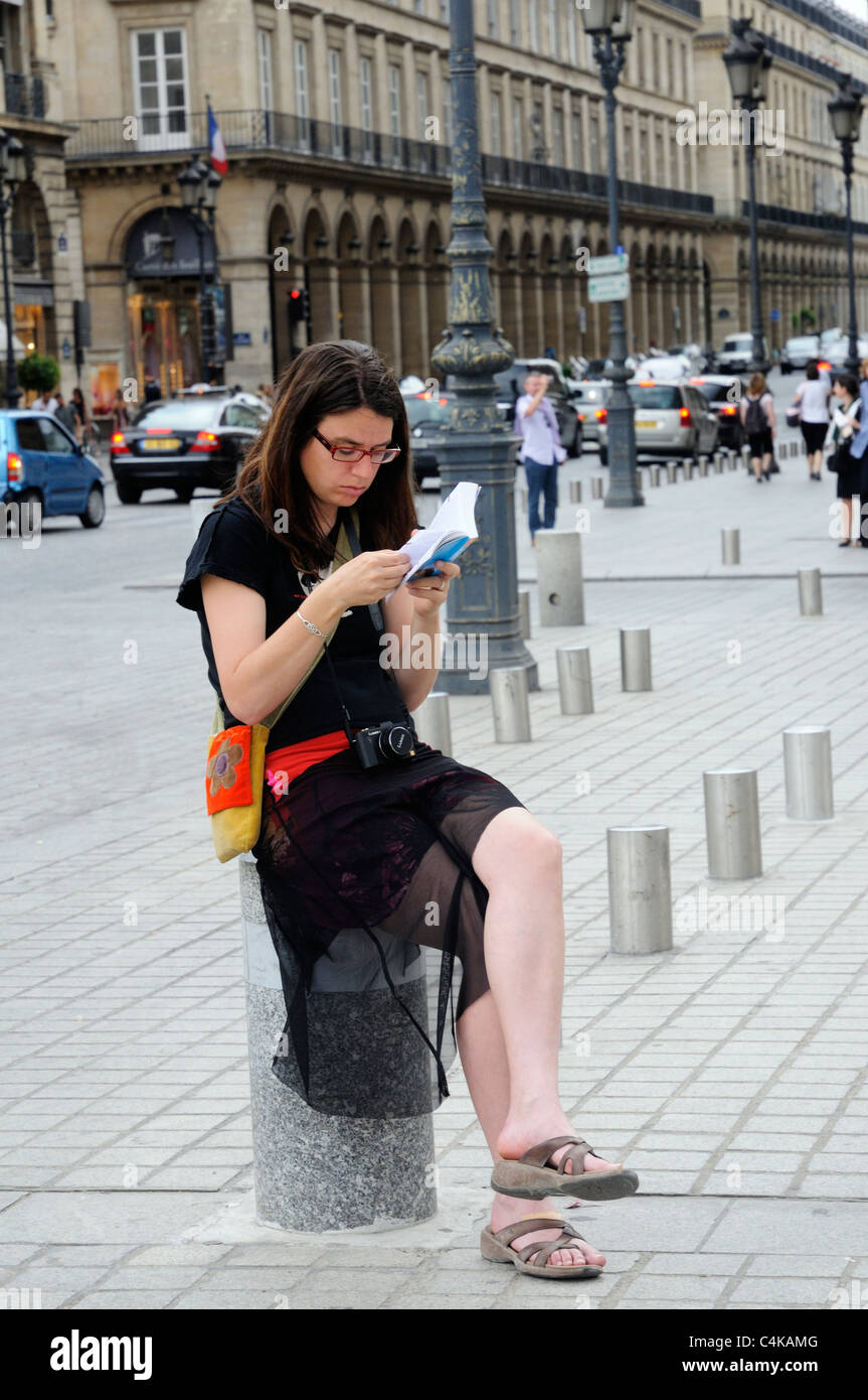 Ein Tourist einen Reiseführer in Place Vendome, Paris lesen Stockfoto